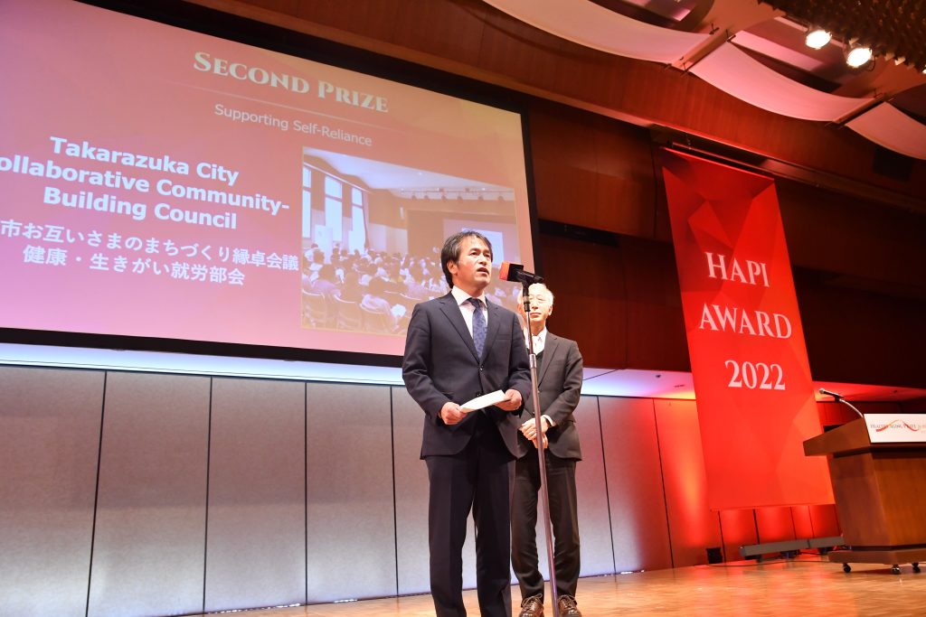 Mr. Toshiaki Onza, Chairman of the NGO SPICE Works Lab and Mr. Takehiro Morikawa, Director of the Community Welfare and Services Division of Takarazuka-City accepted the Second Prize for Supporting Self-Reliance.